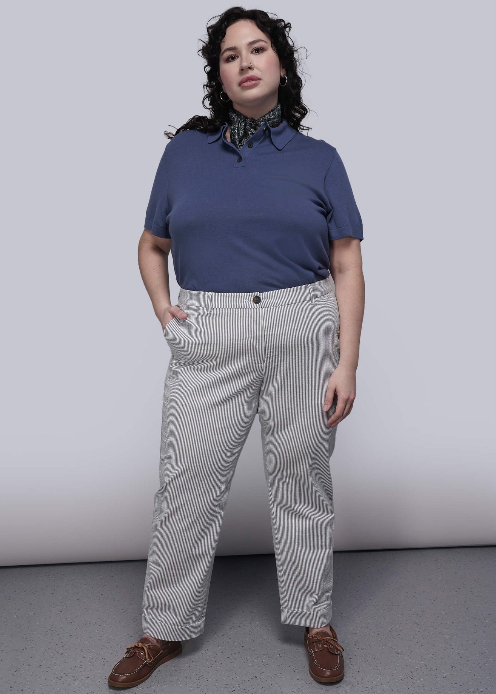 1X=Person wearing a blue shirt and light blue striped pants against a plain background