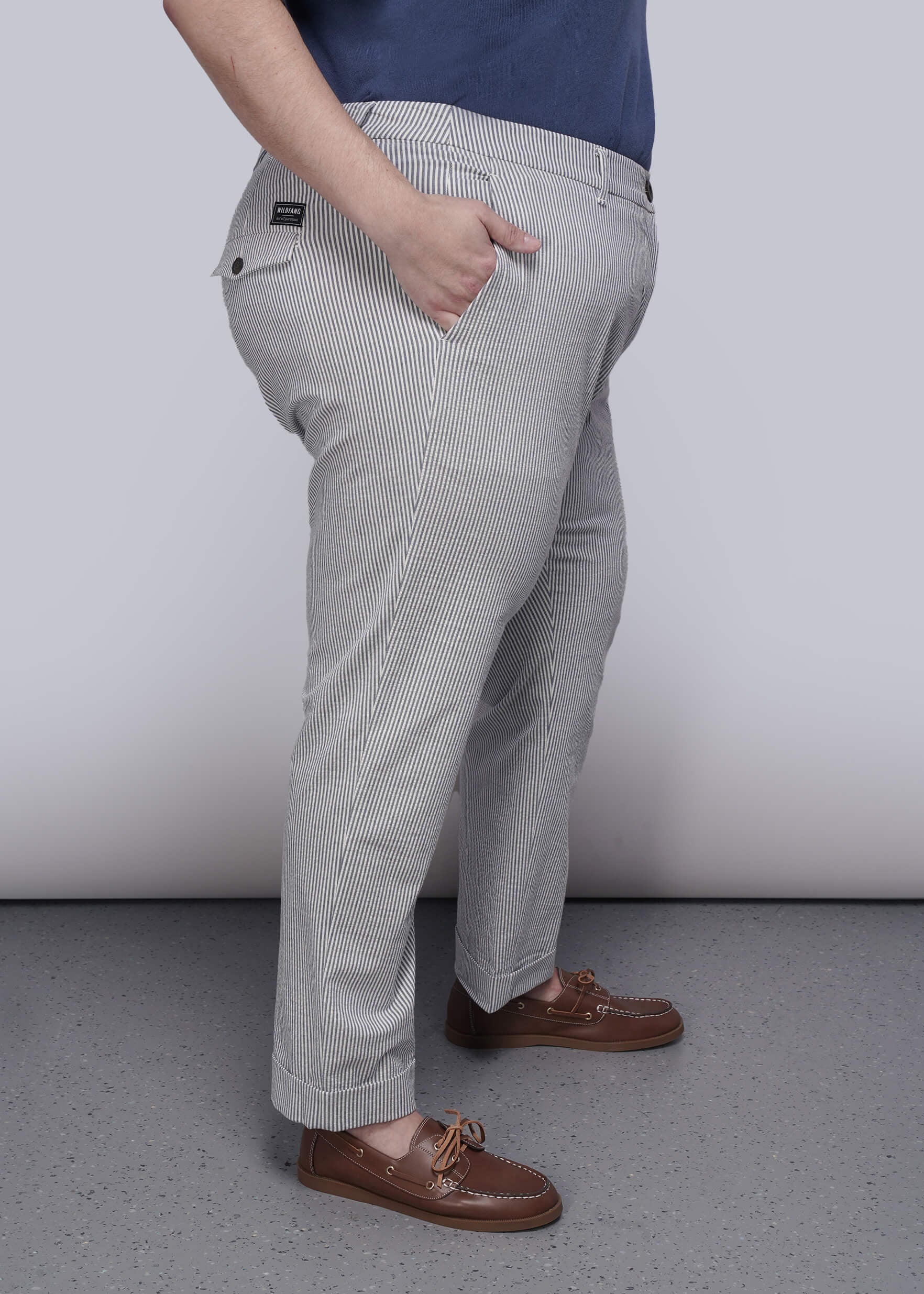 1X=Person wearing light blue striped pants and brown shoes on a plain background