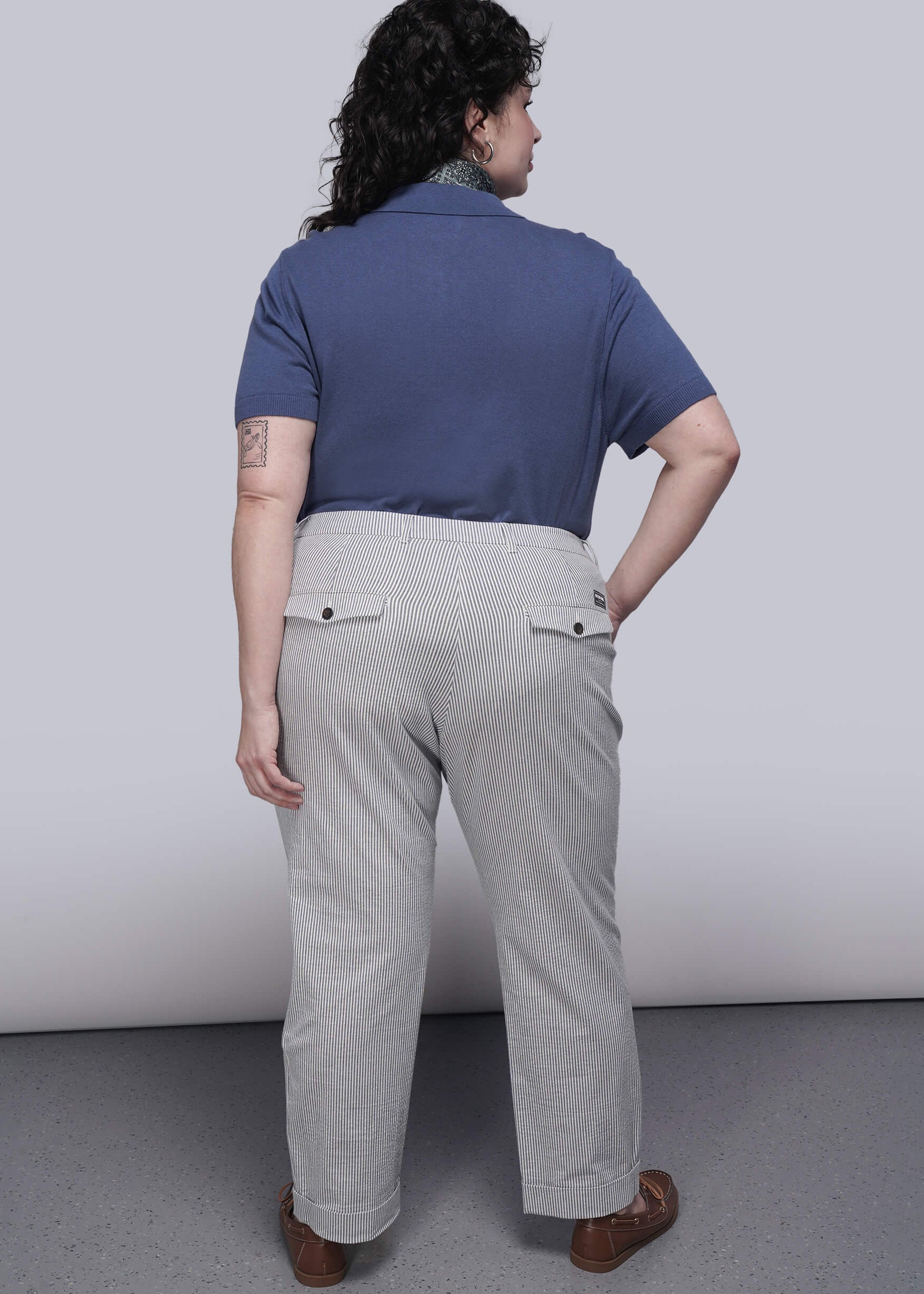 1X=Person wearing a blue shirt and light blue striped pants against a white background