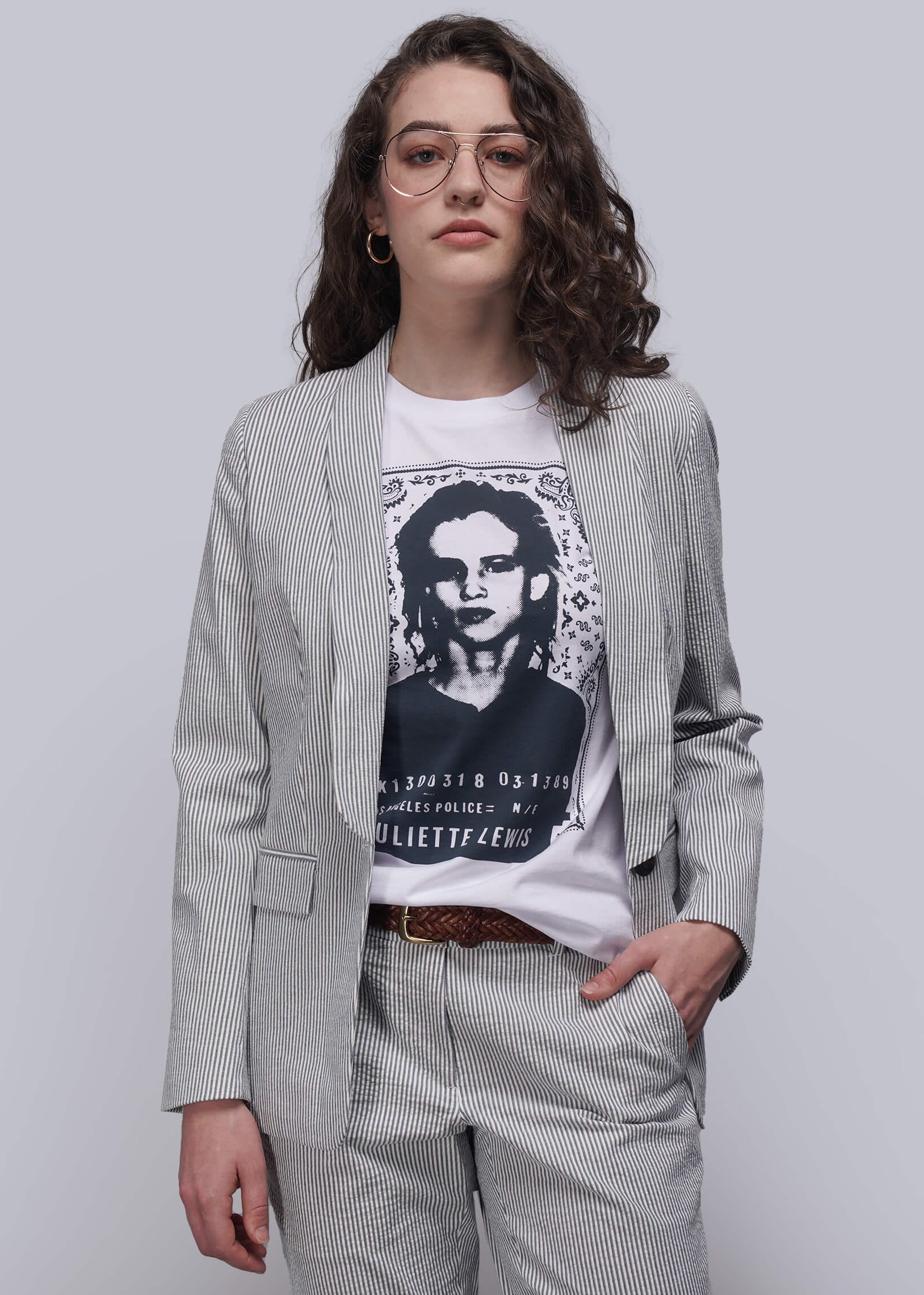 S=Person wearing a light blue striped seersucker blazer over a graphic t-shirt with a plain background