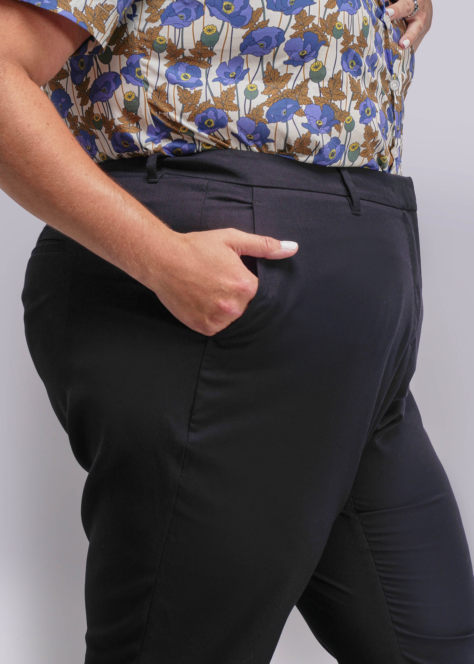 1x=Person wearing a floral shirt and black pants on a plain background