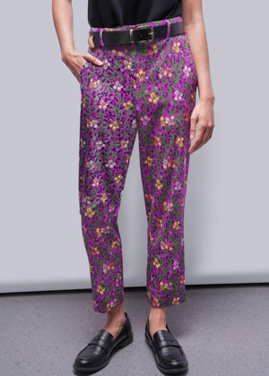 S=Person wearing purple floral pants with a plain background