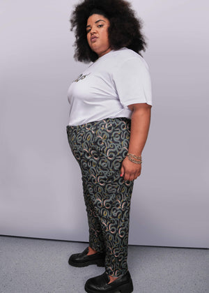 1X=Person wearing a white t-shirt and patterned pants against a plain background