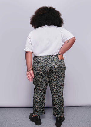 1X=Person wearing a white t-shirt and patterned pants against a plain background