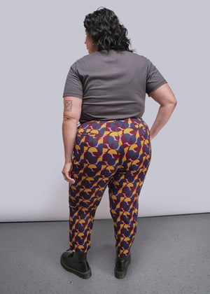 S=Person wearing colorful patterned pants and a gray shirt against a plain background