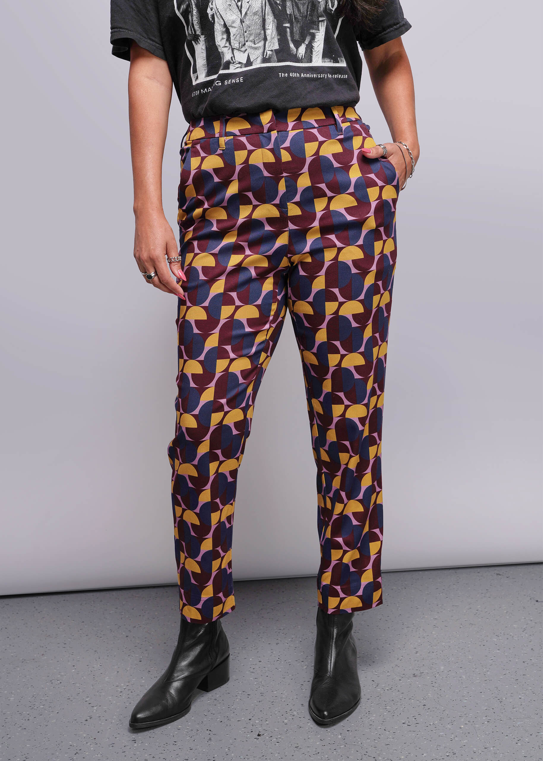 S=Person wearing colorful geometric-patterned pants with a plain background