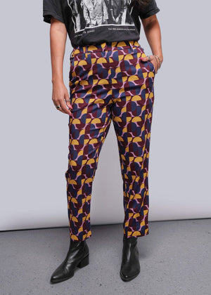 S=Person wearing colorful geometric-patterned pants with a plain background