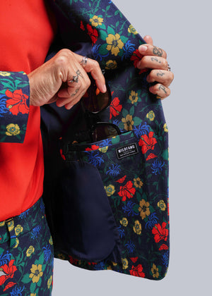 S=Person holding a floral-patterned jacket with a visible brand label.