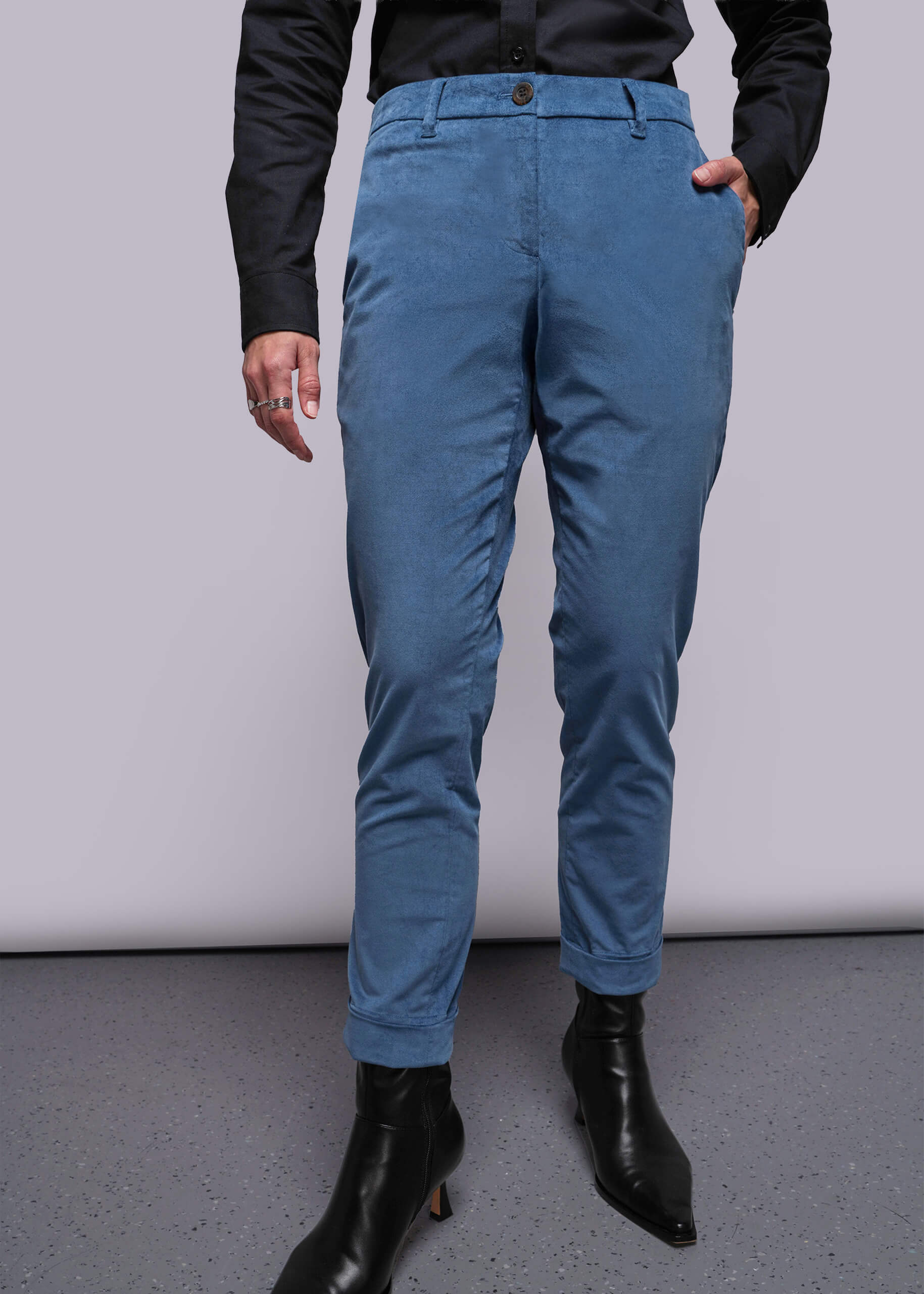 S=Person wearing blue pants and black boots on a plain background