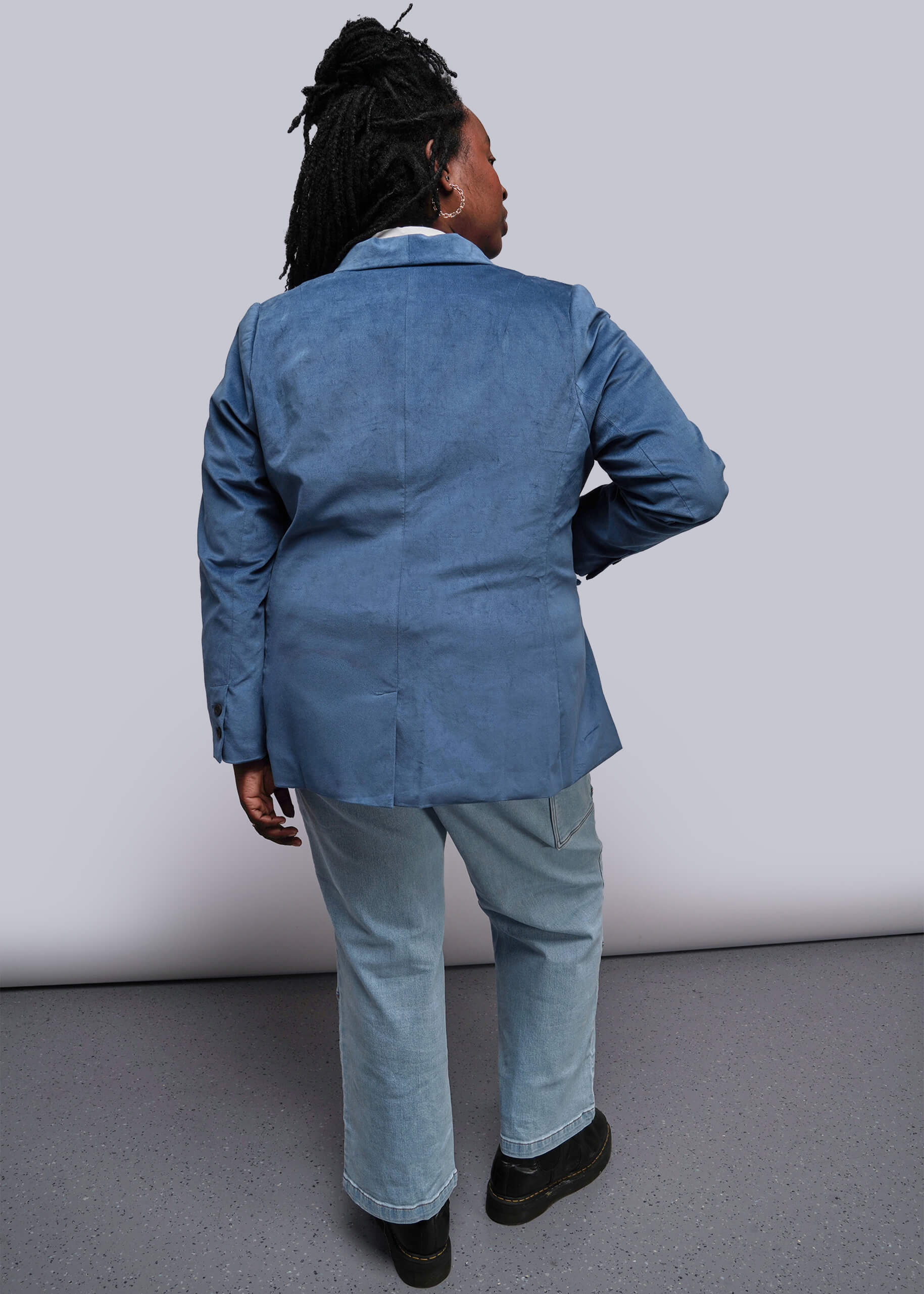 1X=Person wearing a blue jacket and pants against a plain background