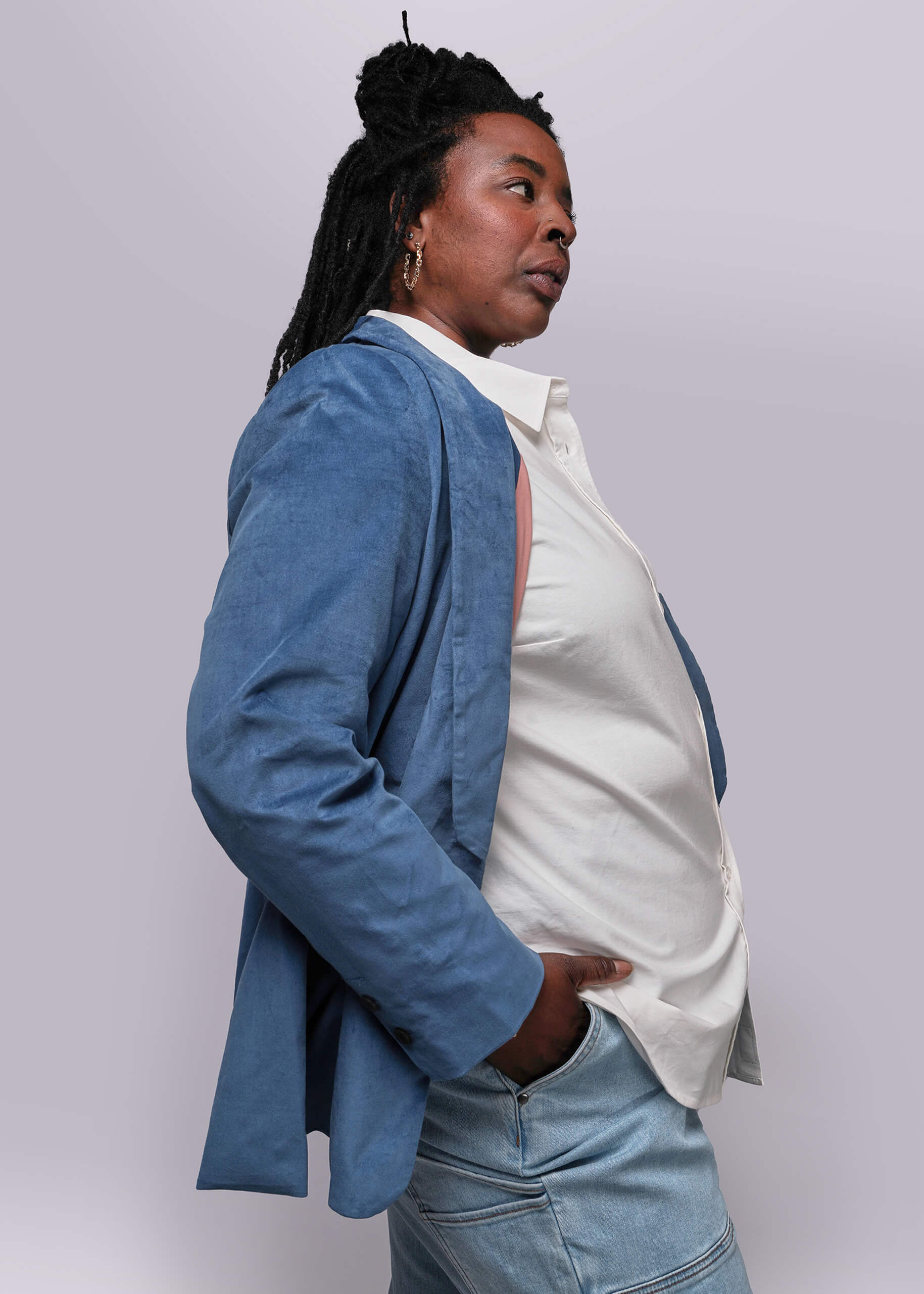 1X=Person wearing a blue blazer over a white shirt on a plain background