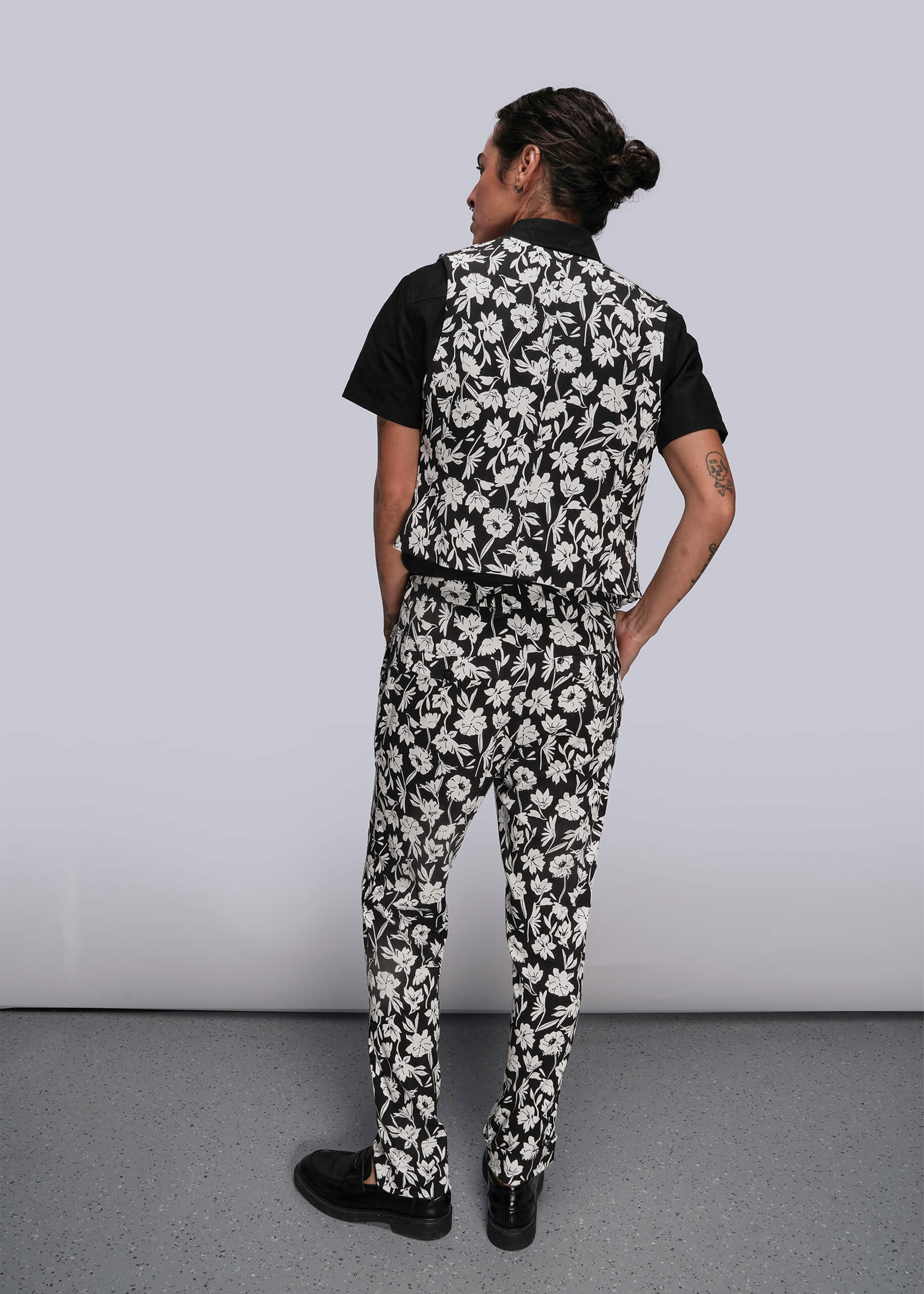 S=Person wearing a black and white floral patterned outfit against a plain background