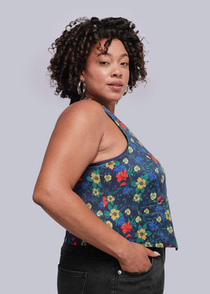 1X=Woman wearing a colorful floral top against a plain background