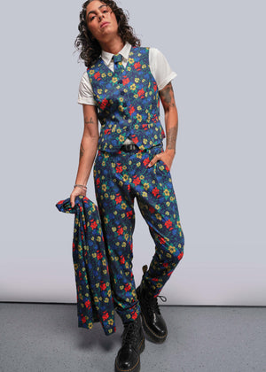 S=Person wearing a colorful floral suit with a white shirt against a plain background