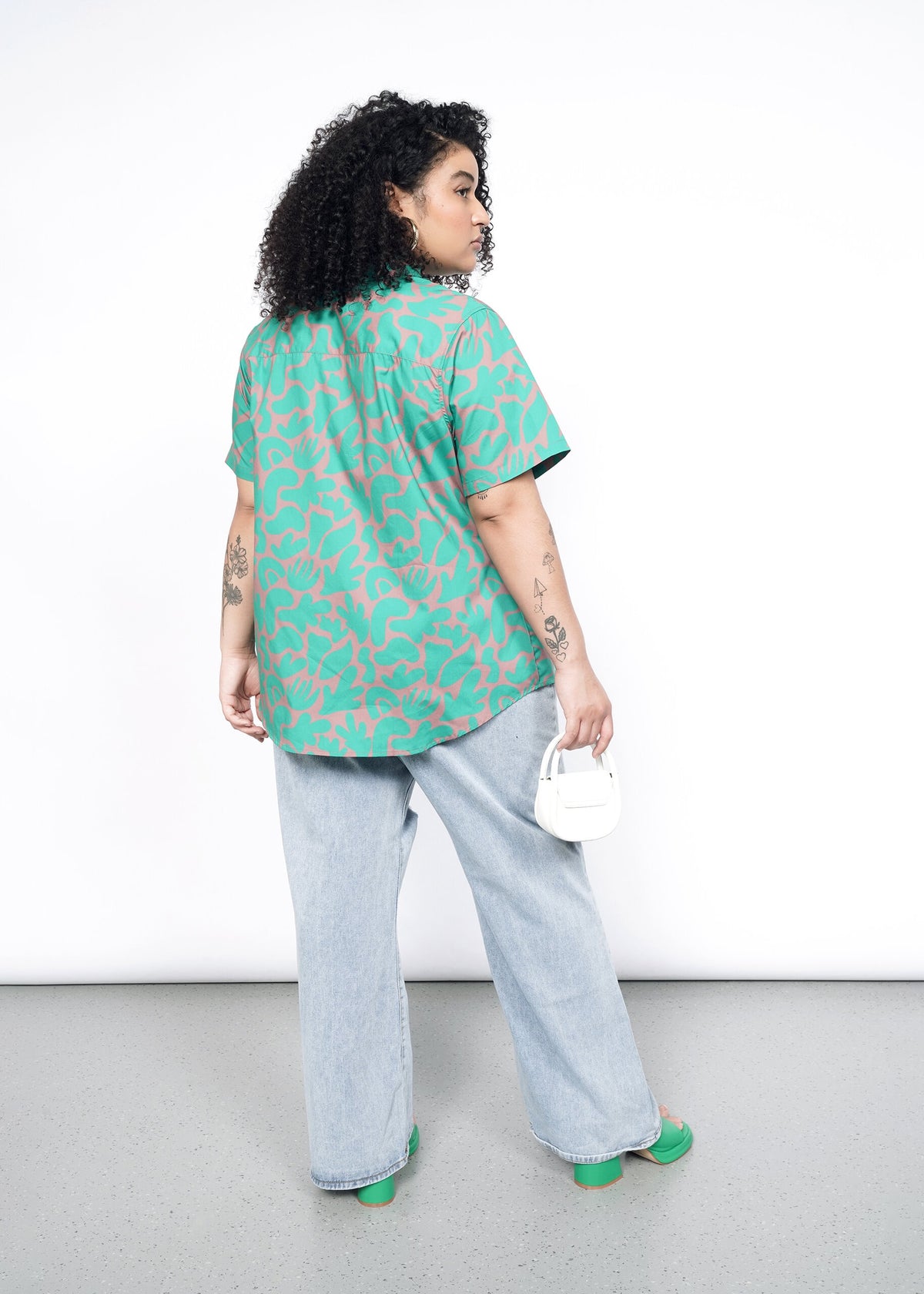 Back image of model wearing the Essential Button Up in Abstract Emerald in size 1X