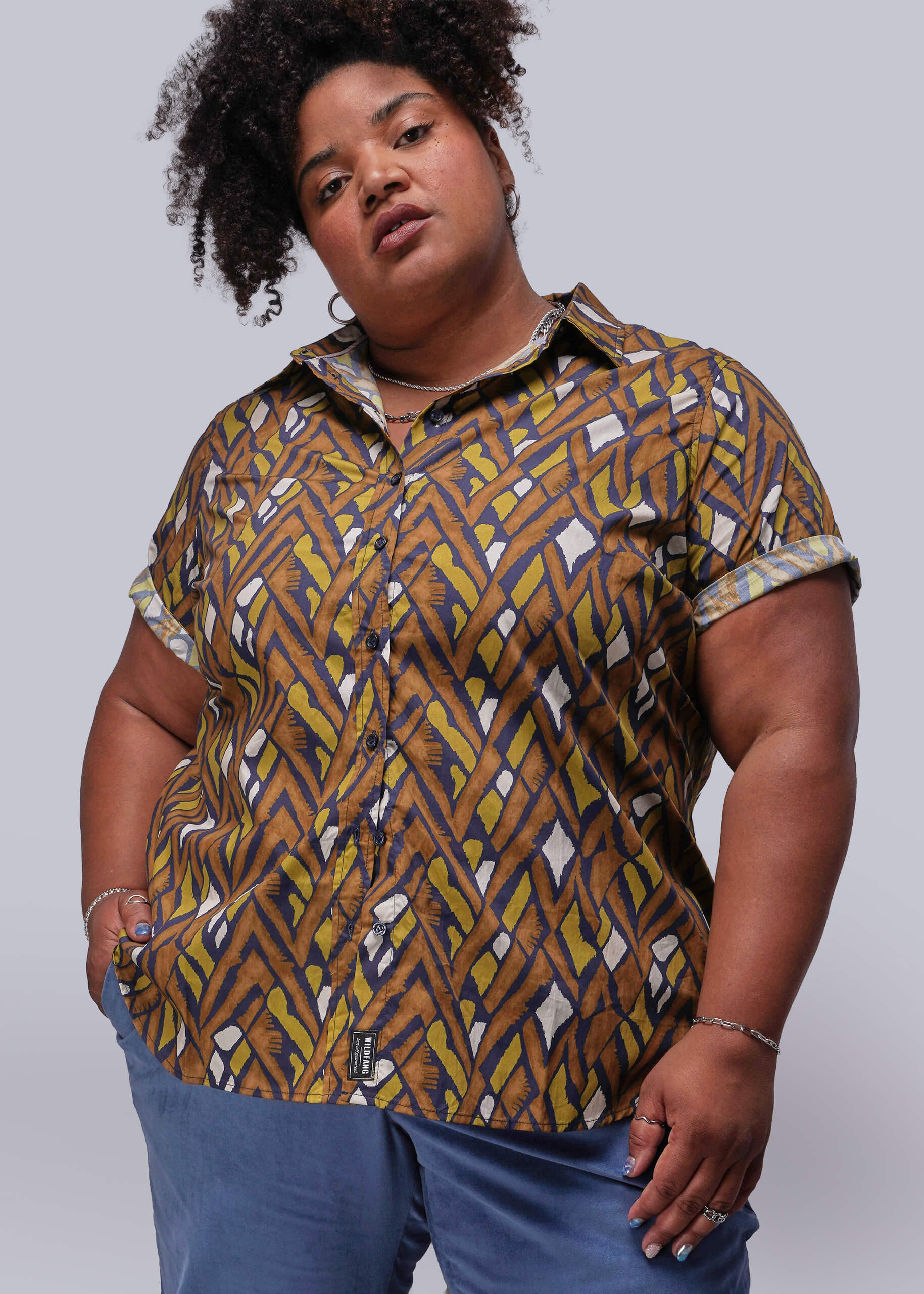 1X=Person wearing a patterned shirt with a plain background