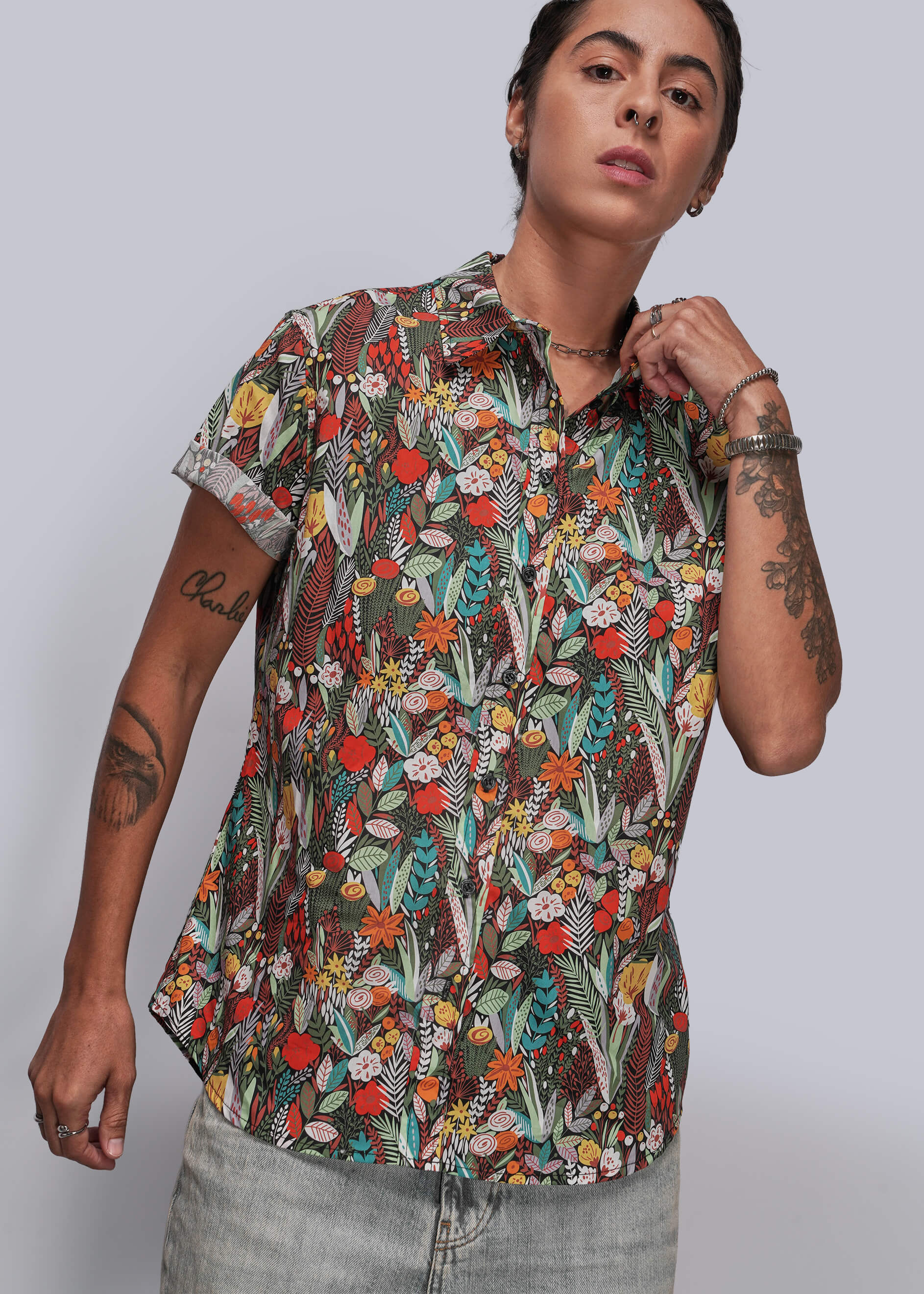 S=Person wearing a colorful floral patterned shirt against a plain background