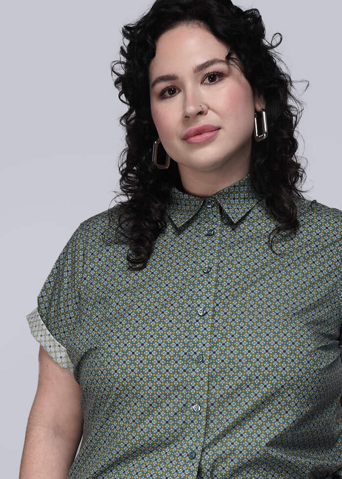 1X=Person wearing a green patterned shirt against a plain background