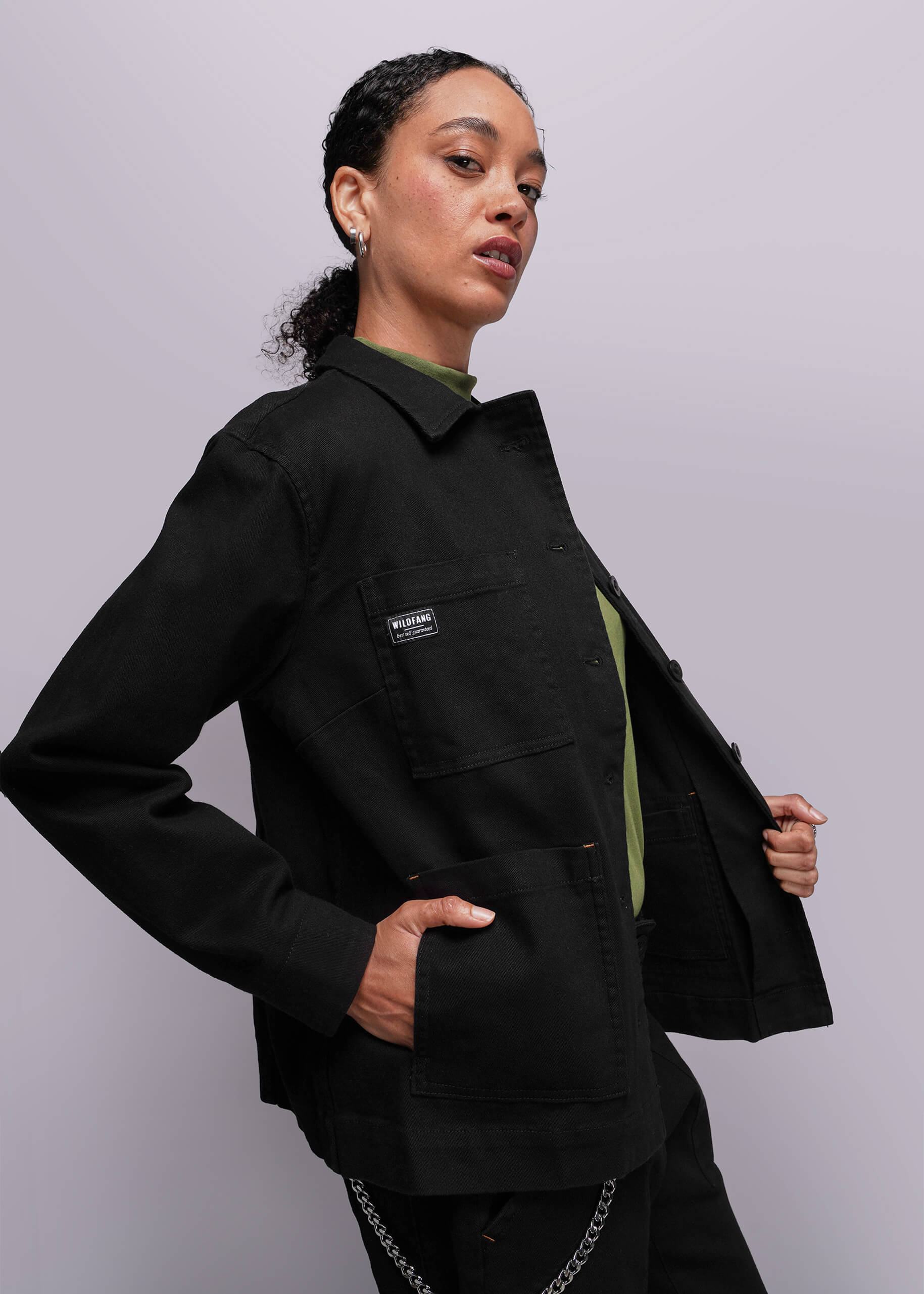 S=Person wearing a black jacket with a visible brand logo on a light gray background