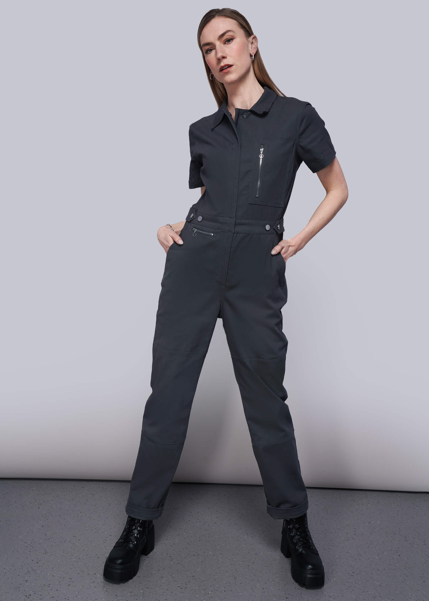 S=Person wearing a black jumpsuit with a plain background