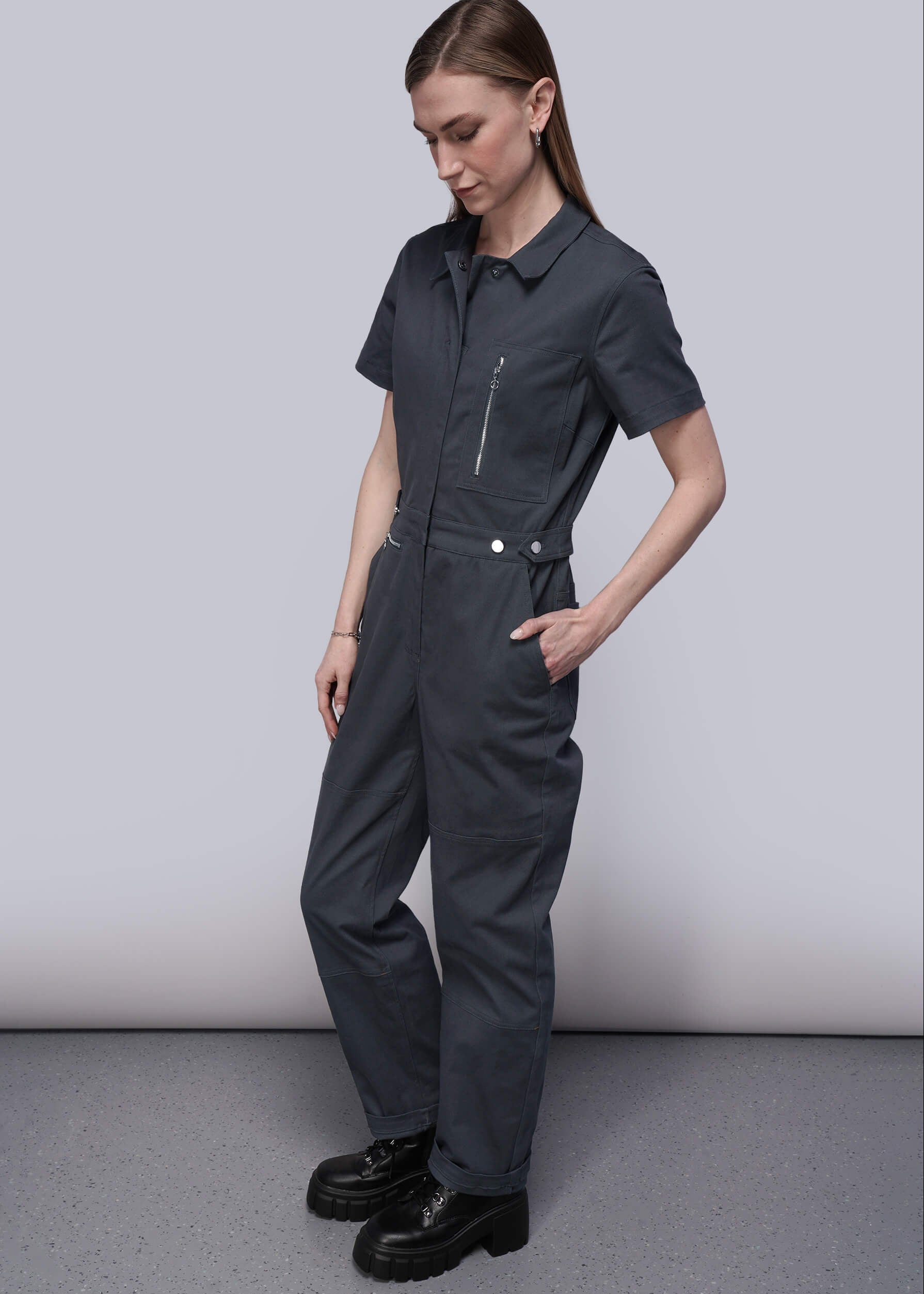 S=Person wearing a black jumpsuit on a plain background