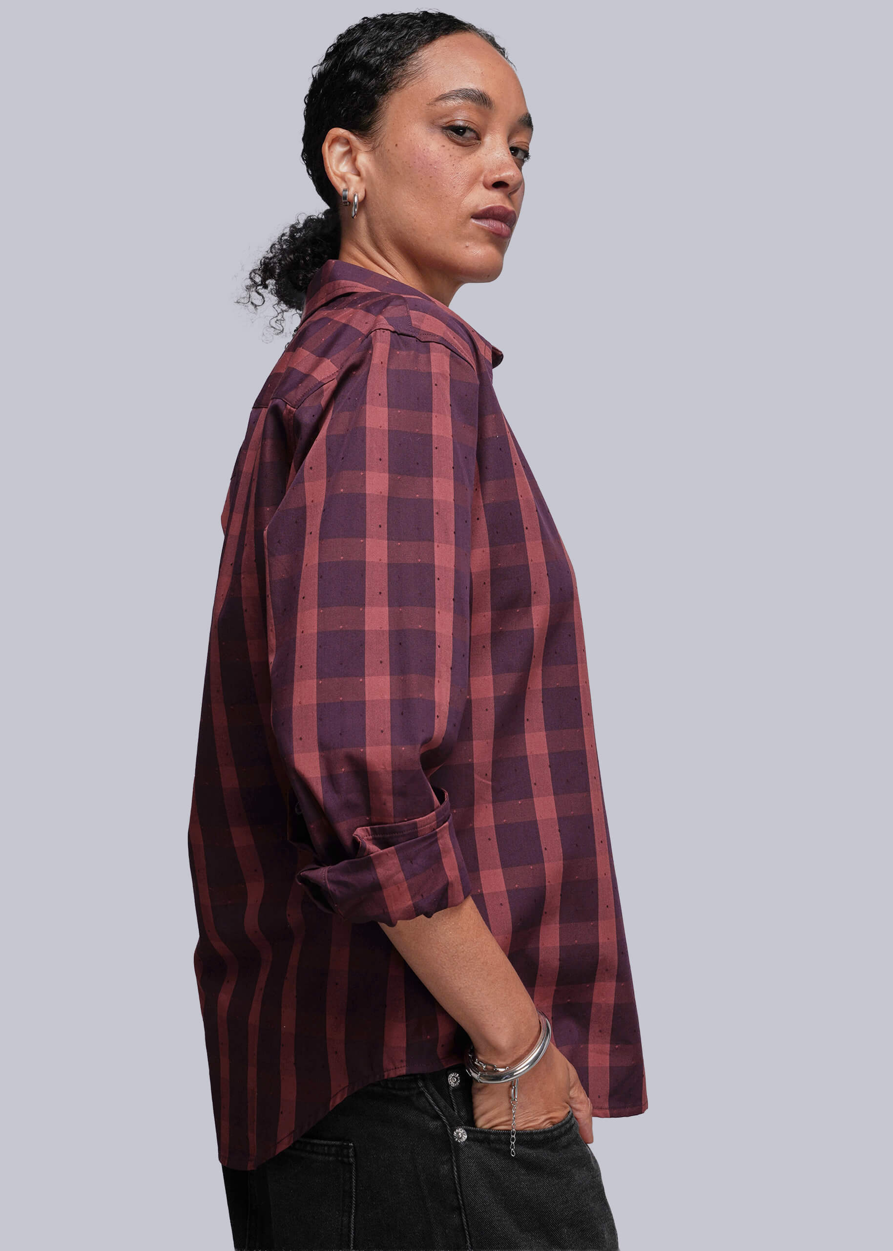 Person wearing a red plaid shirt against a plain background