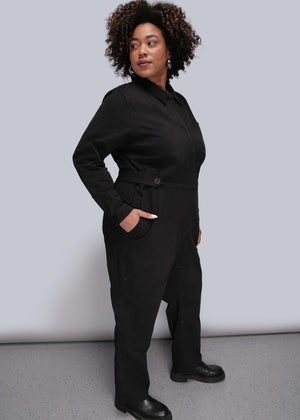 1X=Person wearing a black jumpsuit against a plain background