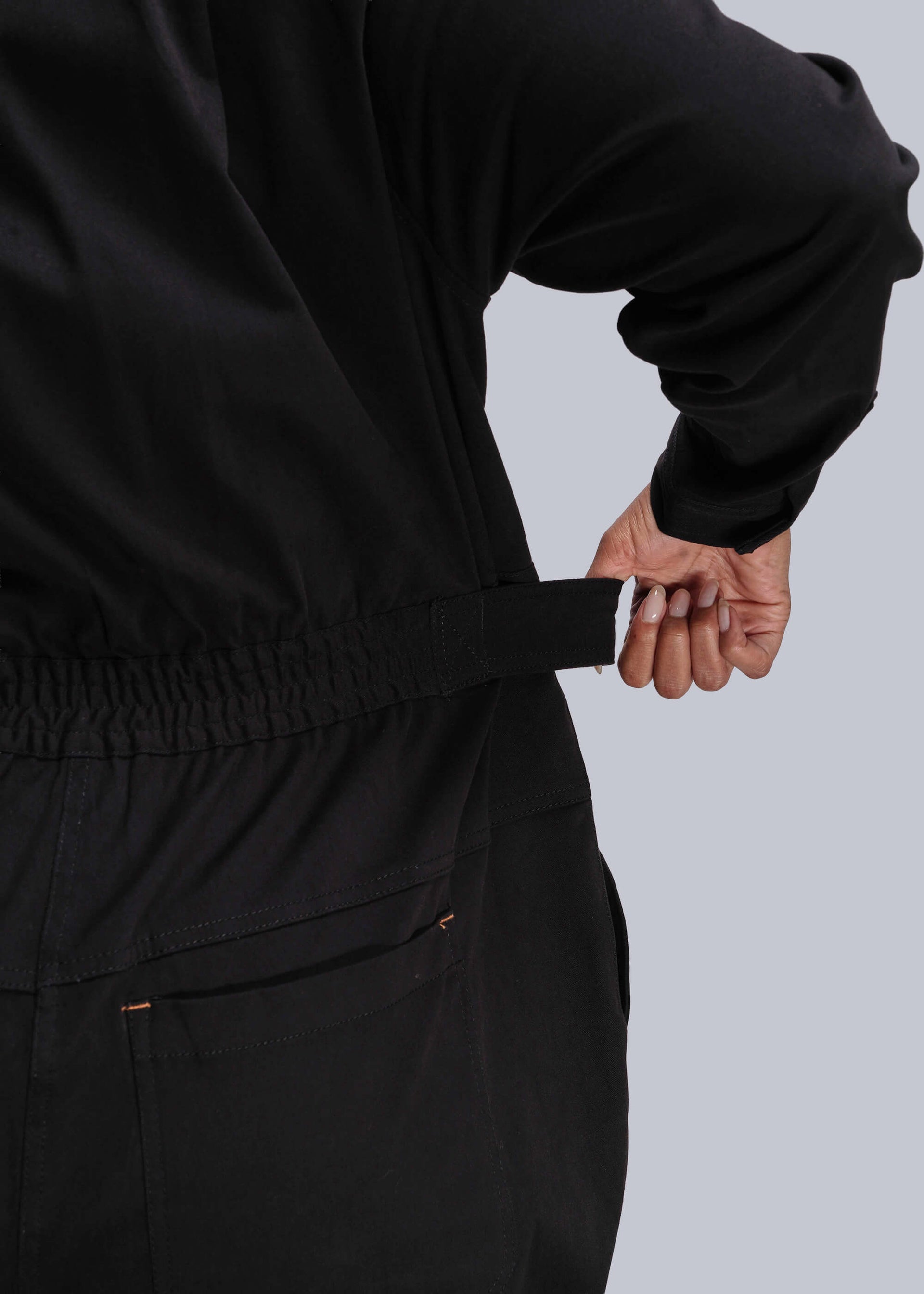 1X=Person wearing a black outfit with a plain background
