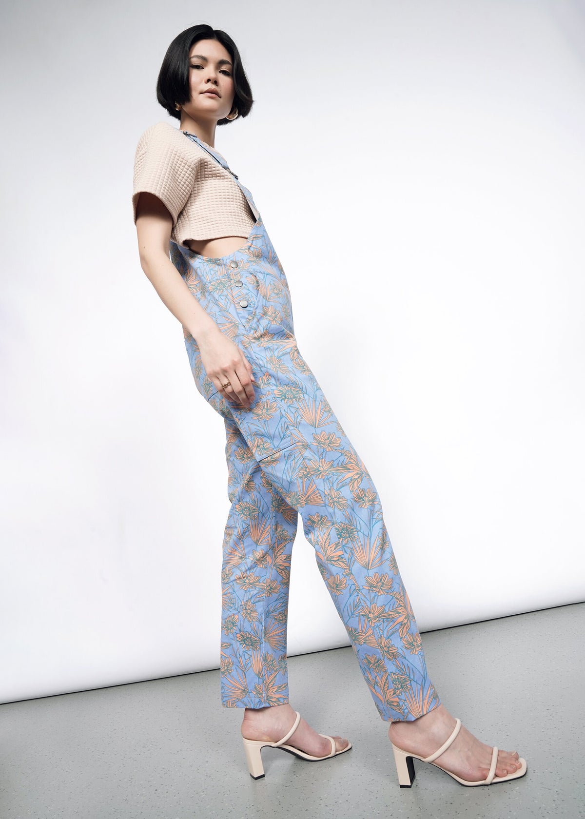 Side image of Model wearing the Essential Overall in Flower Press Periwinkle in size S wearing tan T and tan strappy heeled sandals