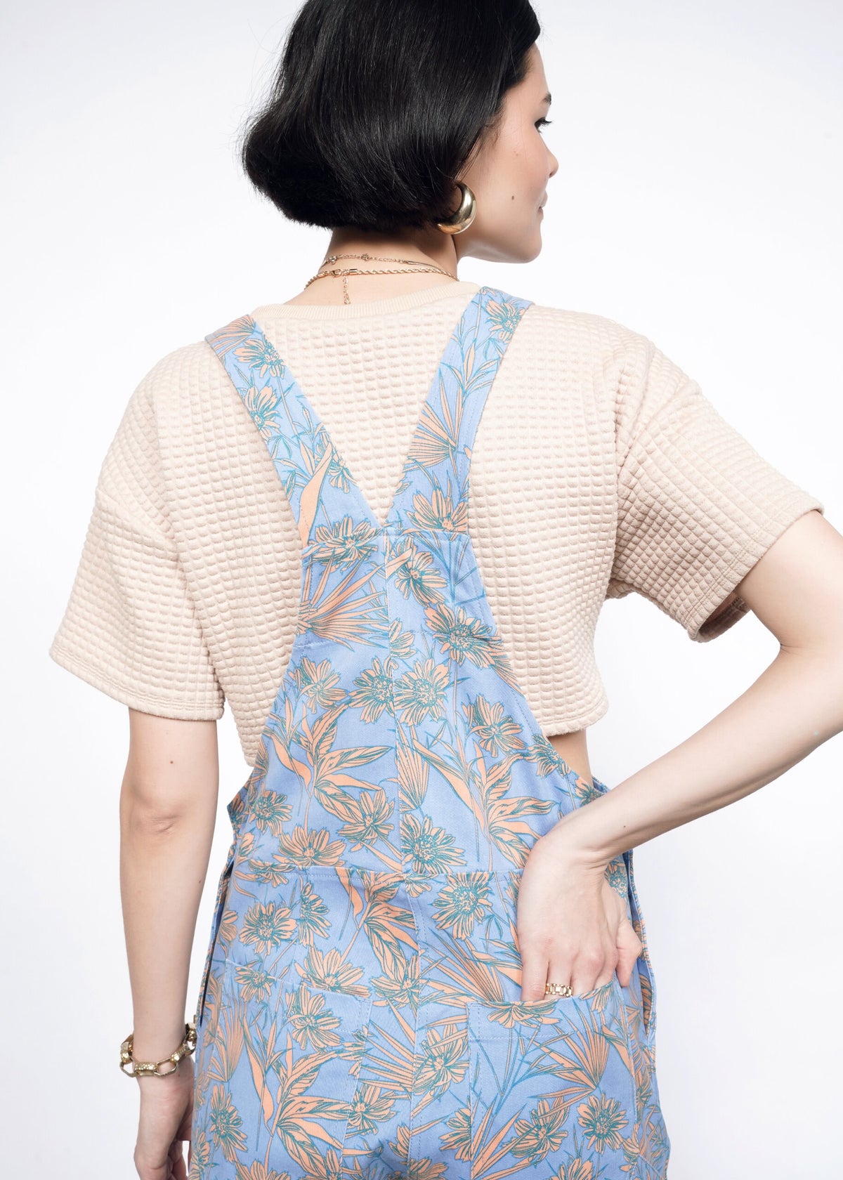 Back image of Model wearing the Essential Overall in Flower Press Periwinkle in size S wearing tan T