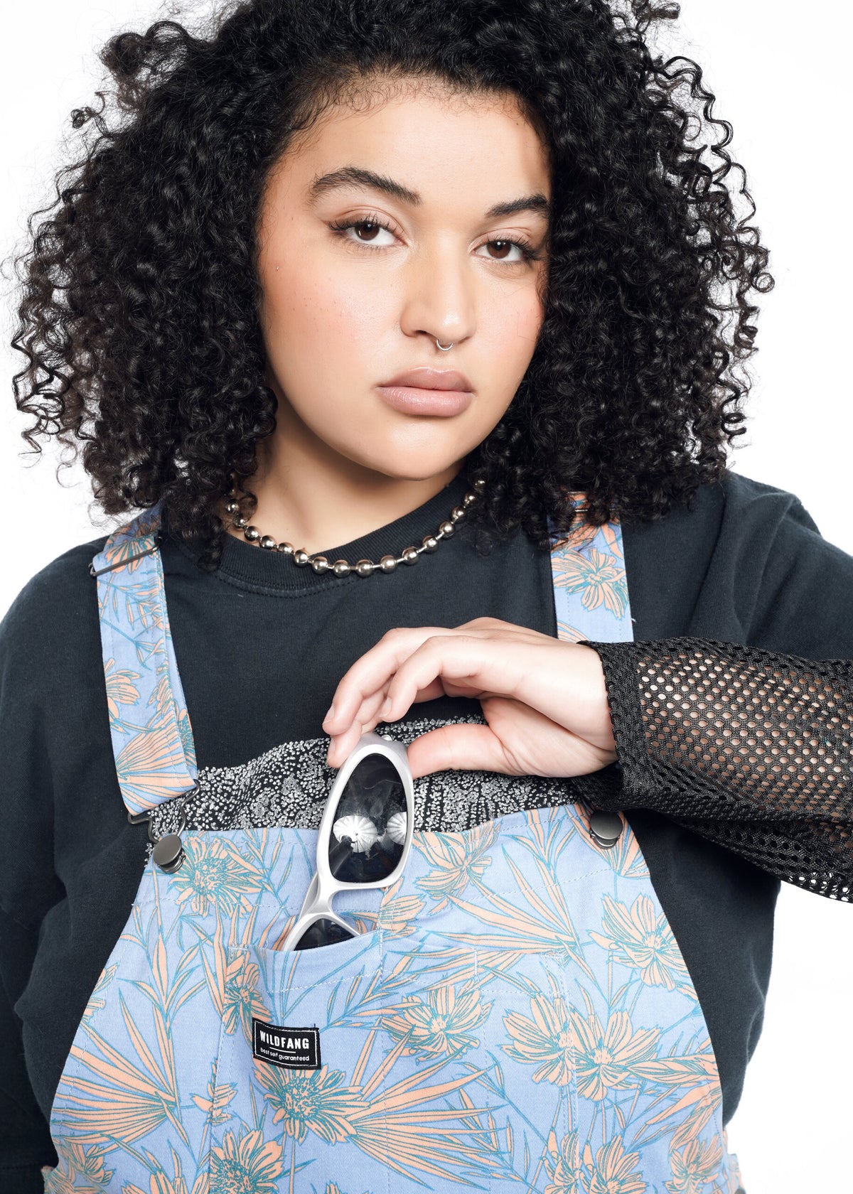 Close-up of Model wearing the Essential Overall in Flower Press Periwinkle in size 1X, wearing black mesh long sleeve shirt and sunglasses