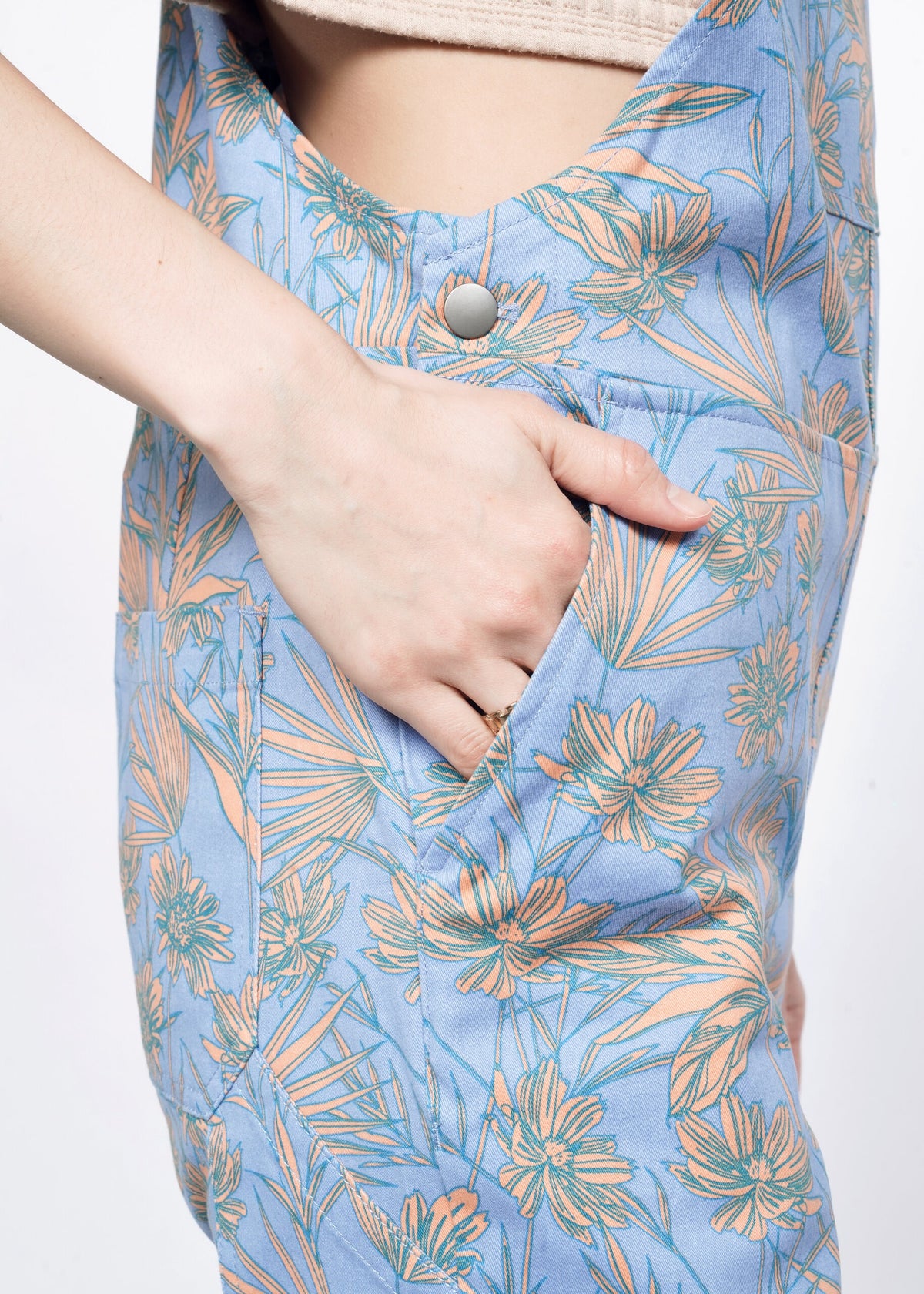 Close-up of Model wearing the Essential Overall in Flower Press Periwinkle in size S wearing tan T, with hand in side pocket