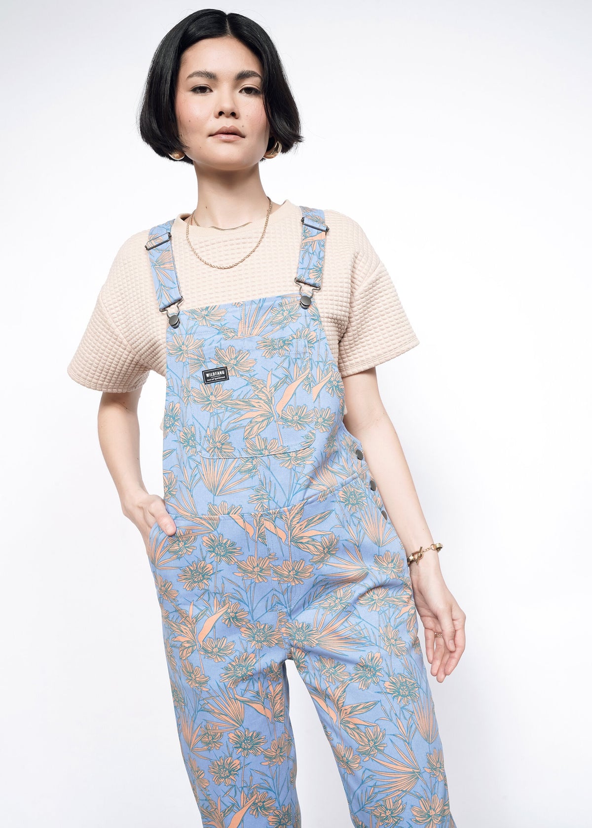 Model wearing the Essential Overall in Flower Press Periwinkle in size S wearing tan T