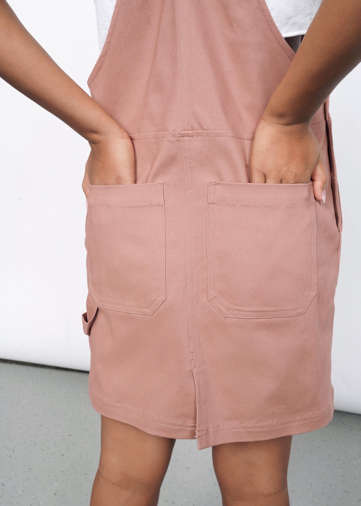 Back image of model wearing Model wearing the Essential Skirtall in Rose Brown in size S, with hands in back pockets.