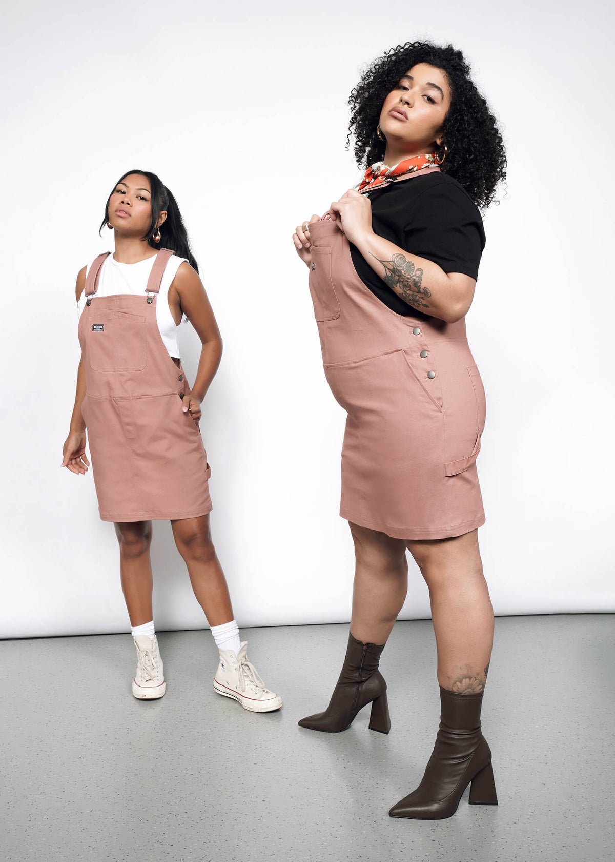 2 Models wearing the Essential Skirtall in Rose Brown. One in size XL with black T, red neck scarf and heeled ankle boots. One in size S with a cropped white tank, white socks, and white high top sneakers. 