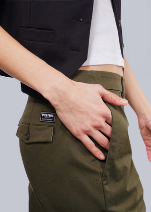 S=Dressed in a cropped black jacket and white shirt, the individual sports The Essential Trouser in olive-green. A classic style with a black WILDFANG label on the back pocket, one hand rests casually within. Set against a plain white background, these pants shine as an effortless wardrobe staple.