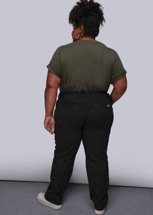 1X=Person wearing a green t-shirt and black pants against a white background