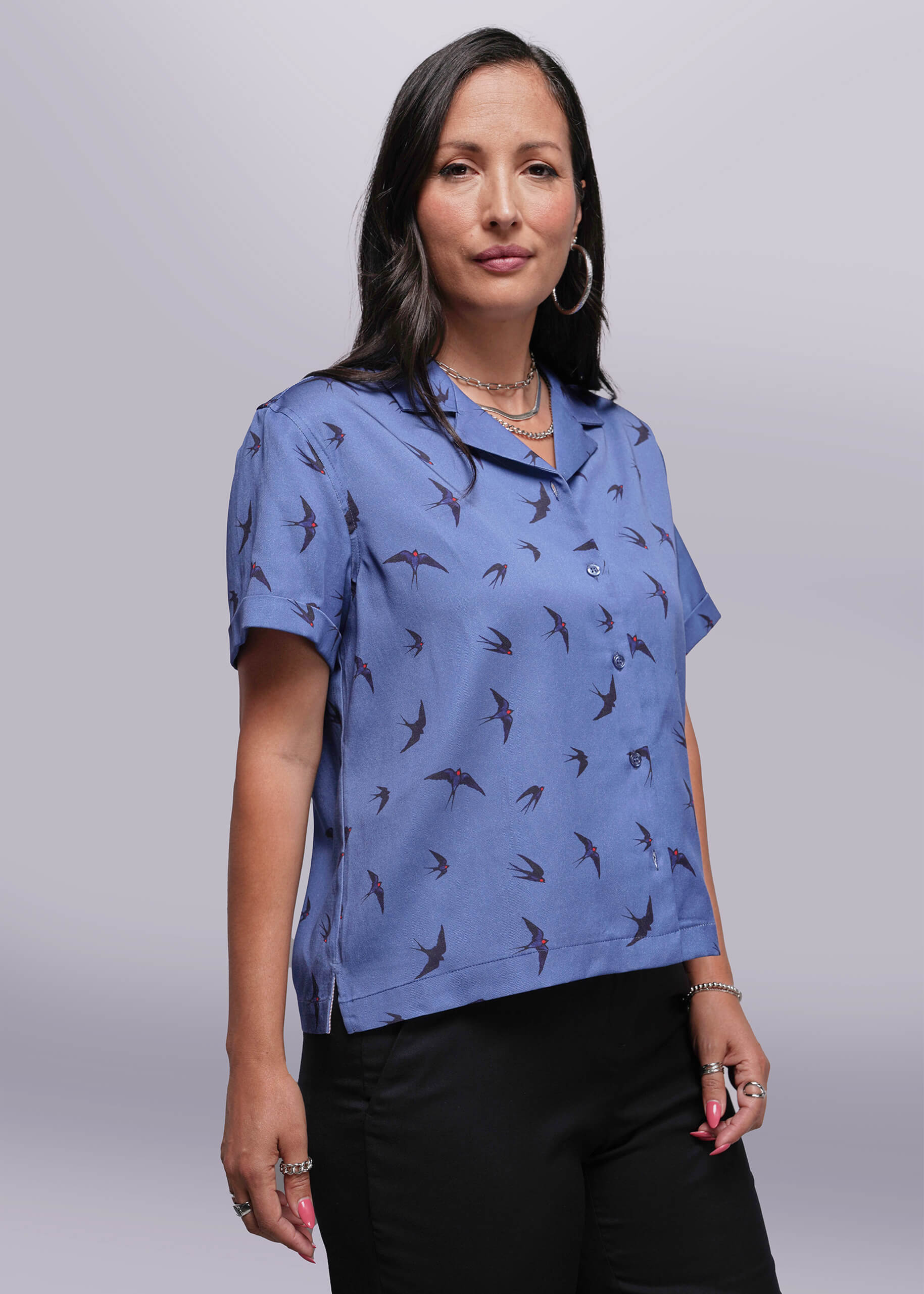 S=Woman wearing a blue patterned shirt against a plain background