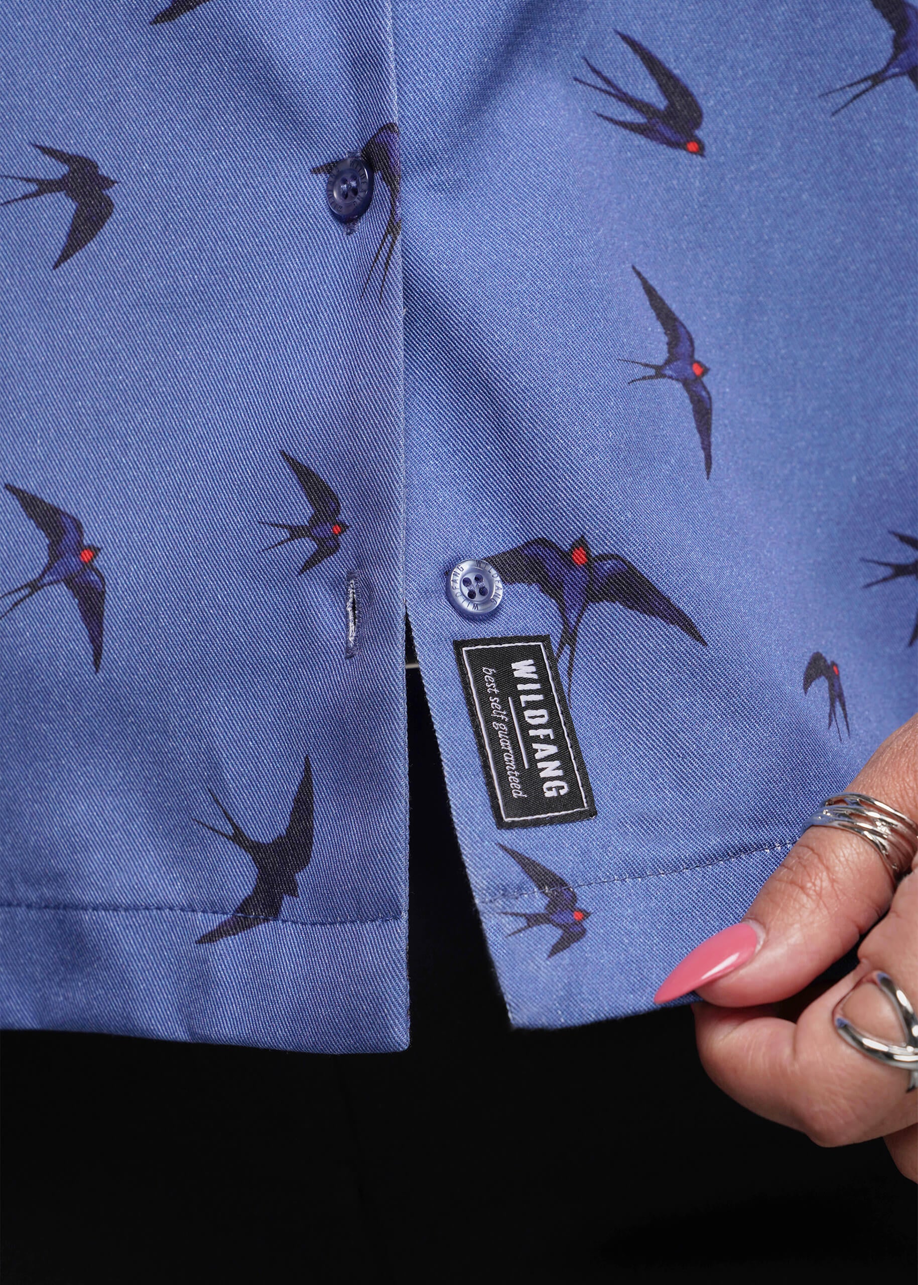 S=Blue shirt with bird pattern held by a hand, Wildfang brand visible