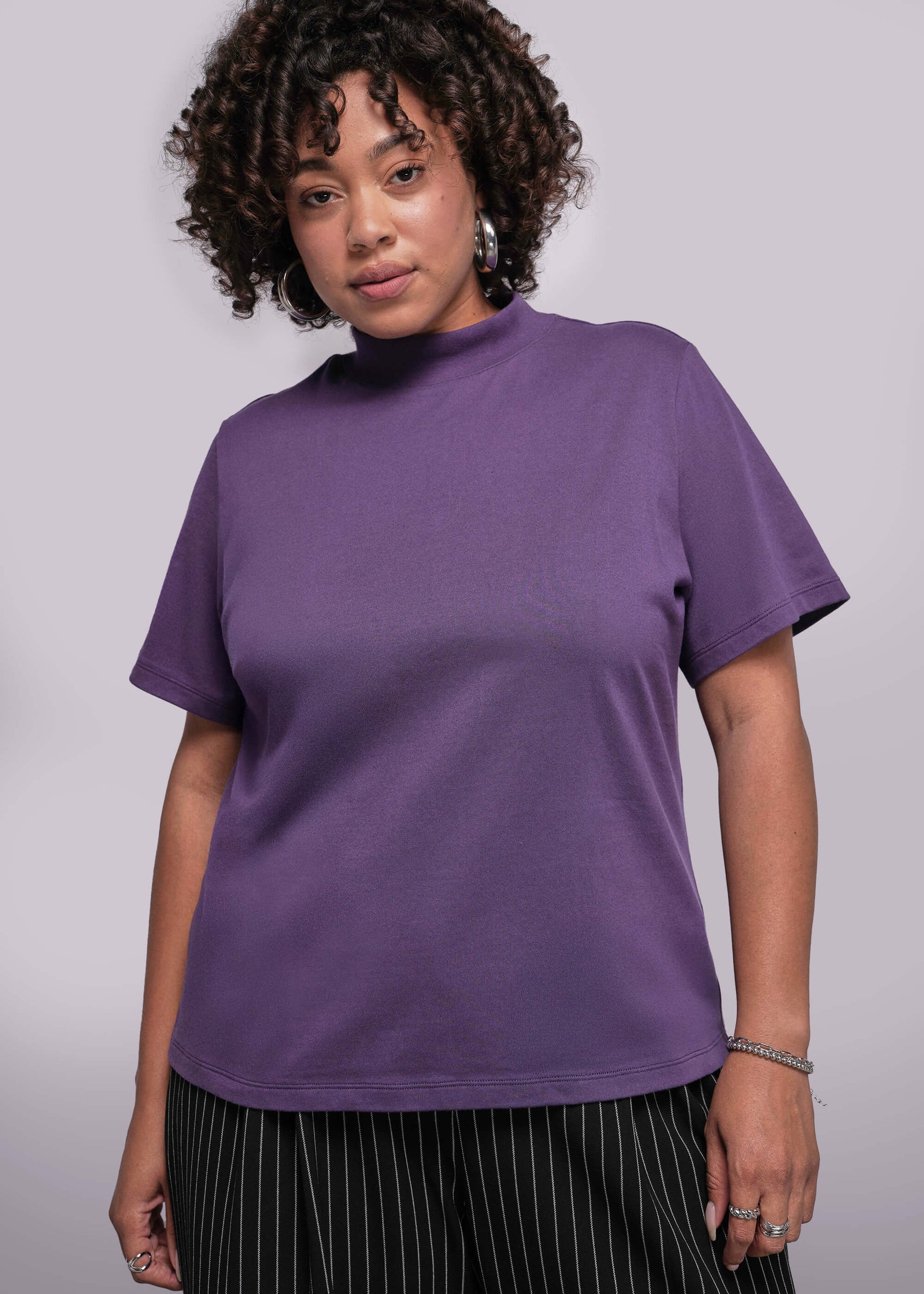 1X=Person wearing a purple t-shirt against a plain background