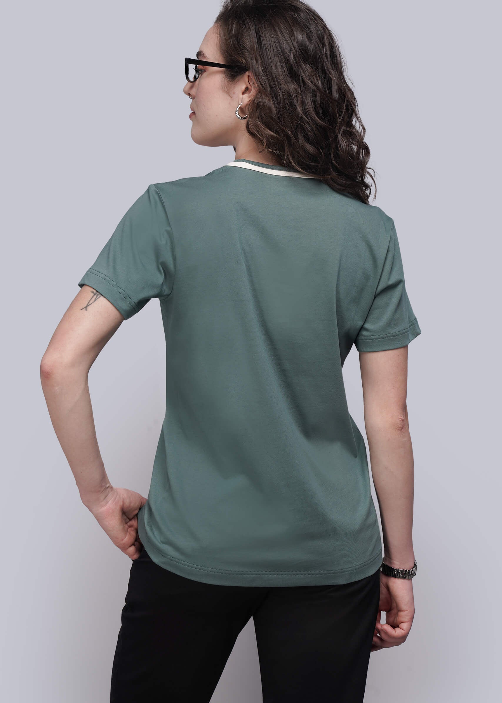 S=Person wearing a green t-shirt and black pants on a plain background