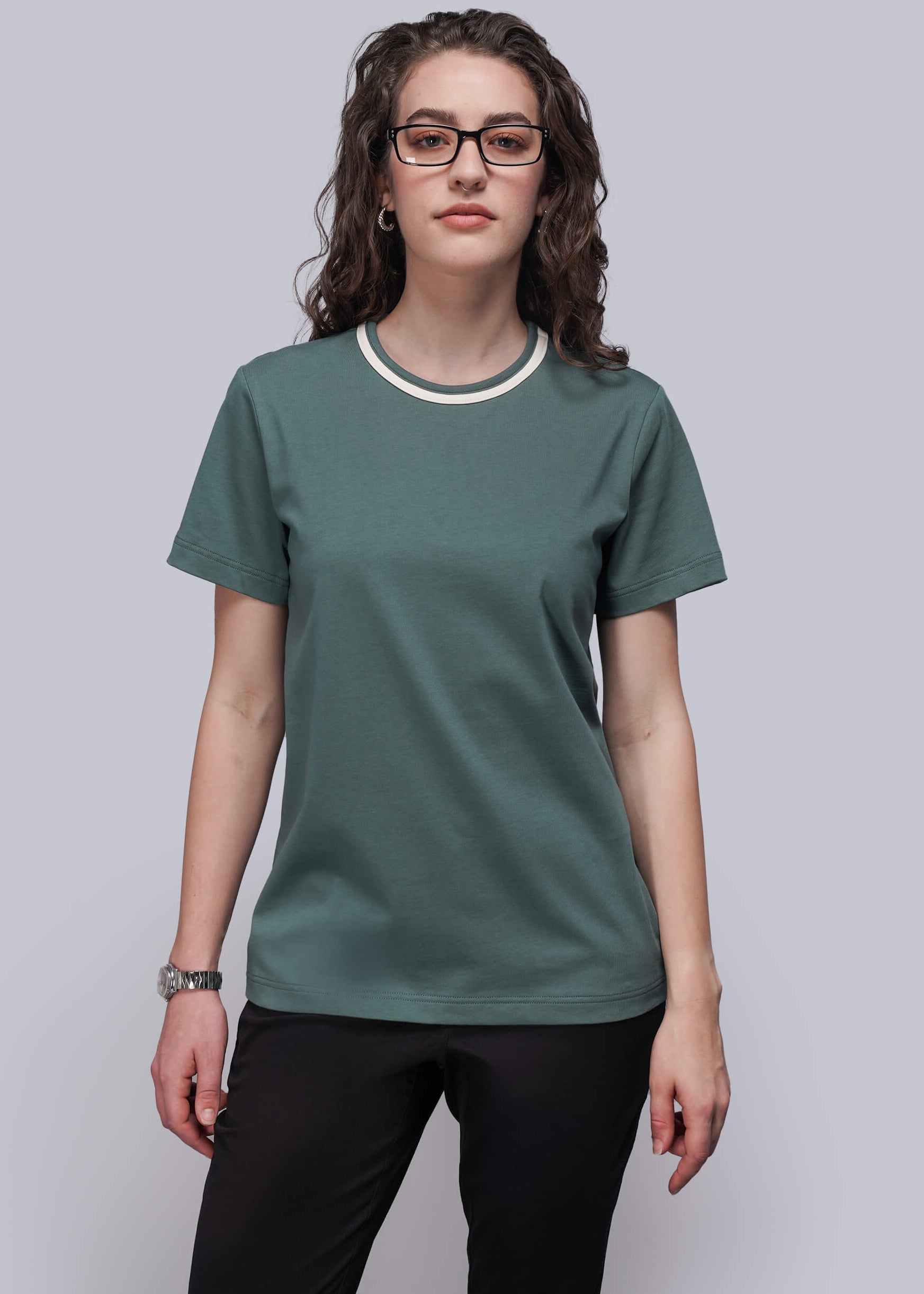 S=Person wearing a green t-shirt with a white collar against a plain background