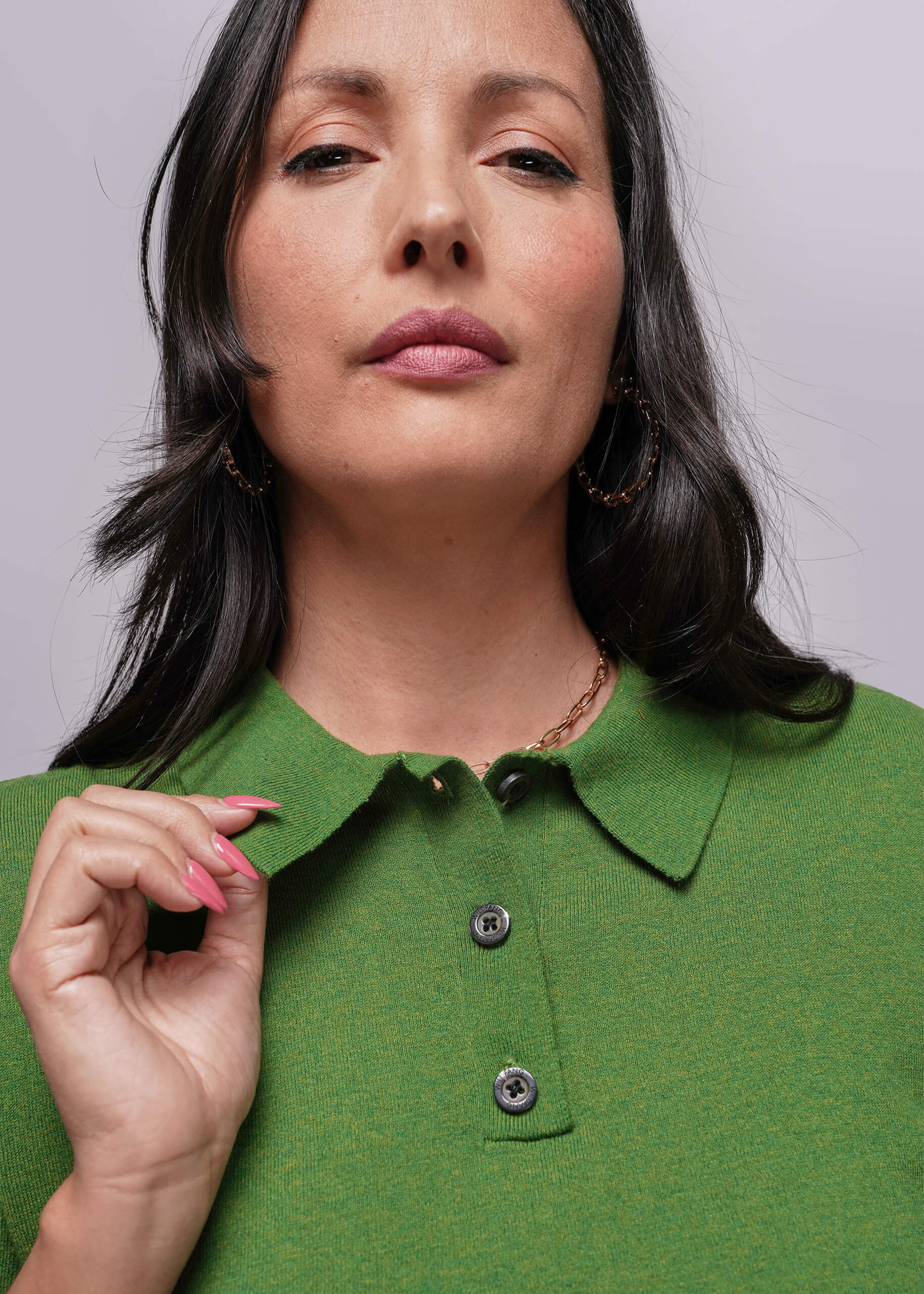 S=Woman wearing a green shirt with a plain background