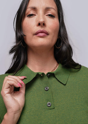 S=Woman wearing a green shirt with a plain background