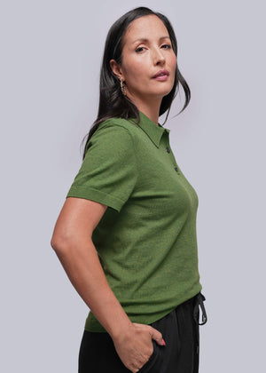S=Woman wearing a green polo shirt against a plain background