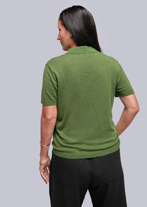 S=Person wearing a green polo shirt and black pants on a gray background