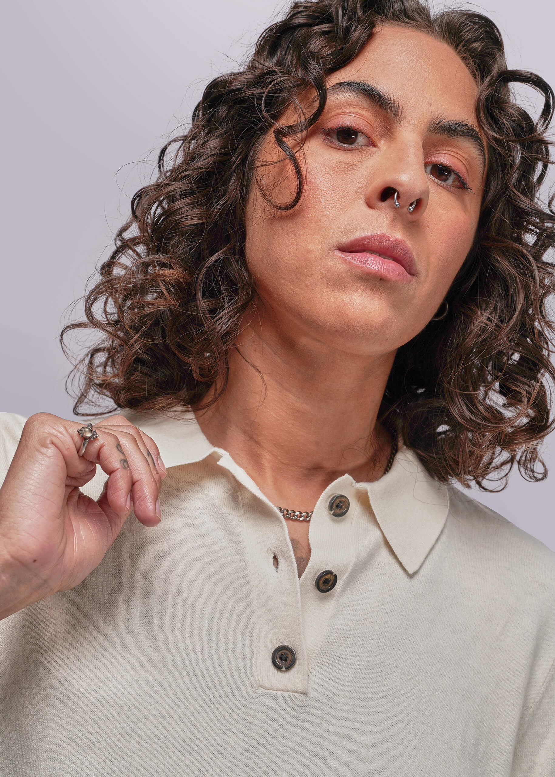 S=Person wearing a light-colored polo shirt with a neutral background