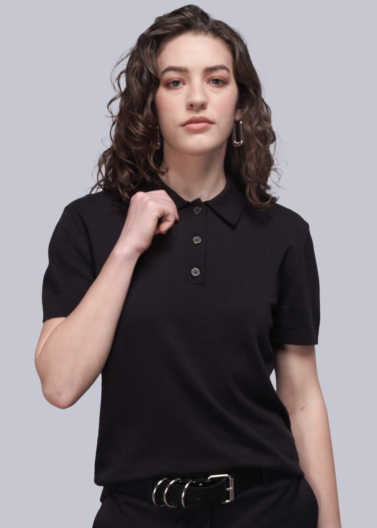 S=Person wearing a black polo shirt and black pants on a gray background