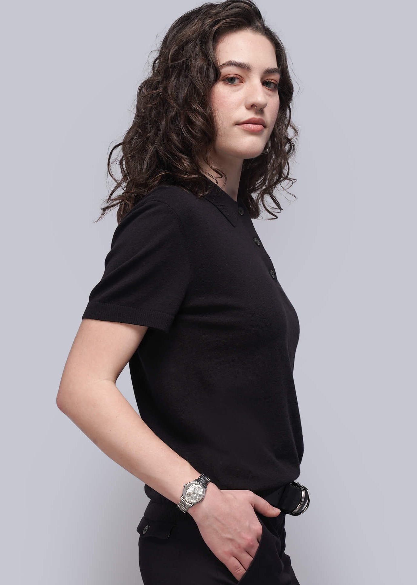 S=Person wearing a black outfit against a light gray background