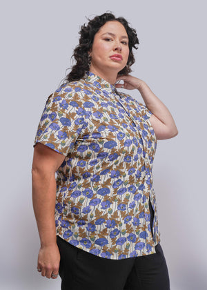 1X=Person wearing a floral patterned shirt against a plain background
